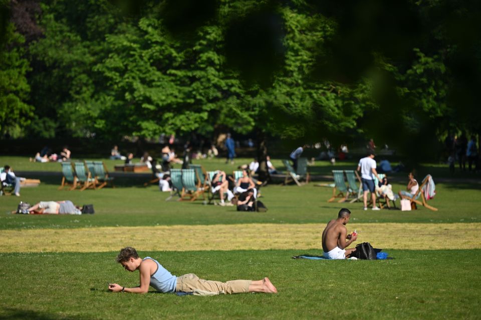 People relaxing in St. James's Park on a warm day.