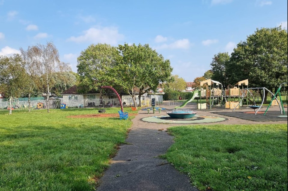 Playground with play structures and grassy areas.