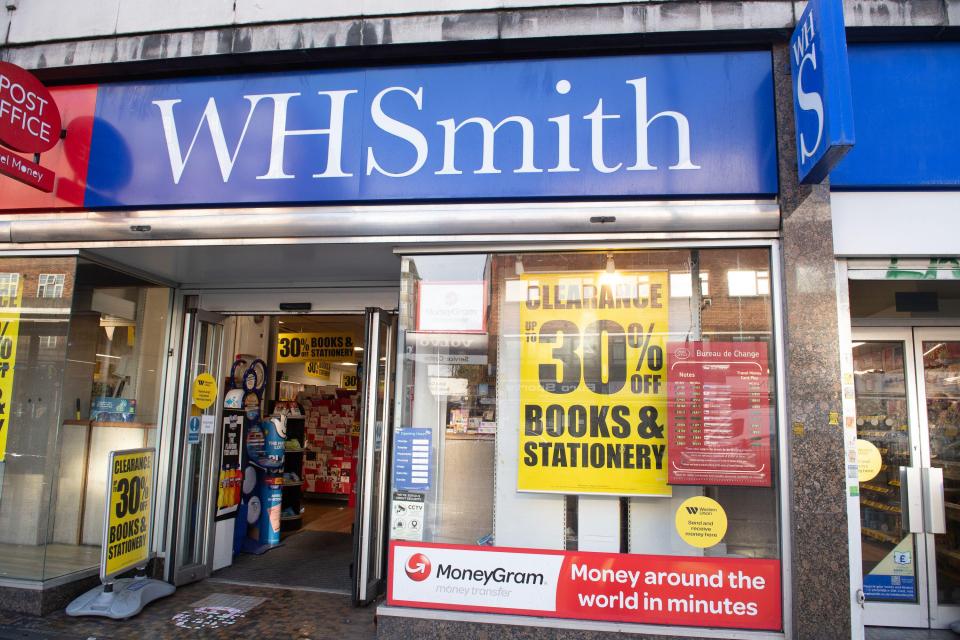 Exterior view of a WH Smith store with a clearance sale sign.