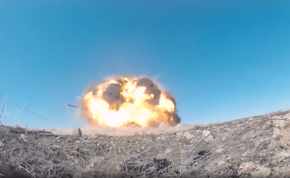 Large explosion in a desert landscape.