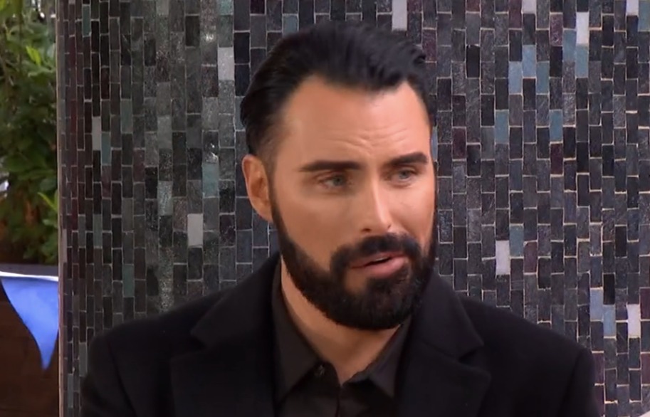 Screenshot of a man with a beard speaking.