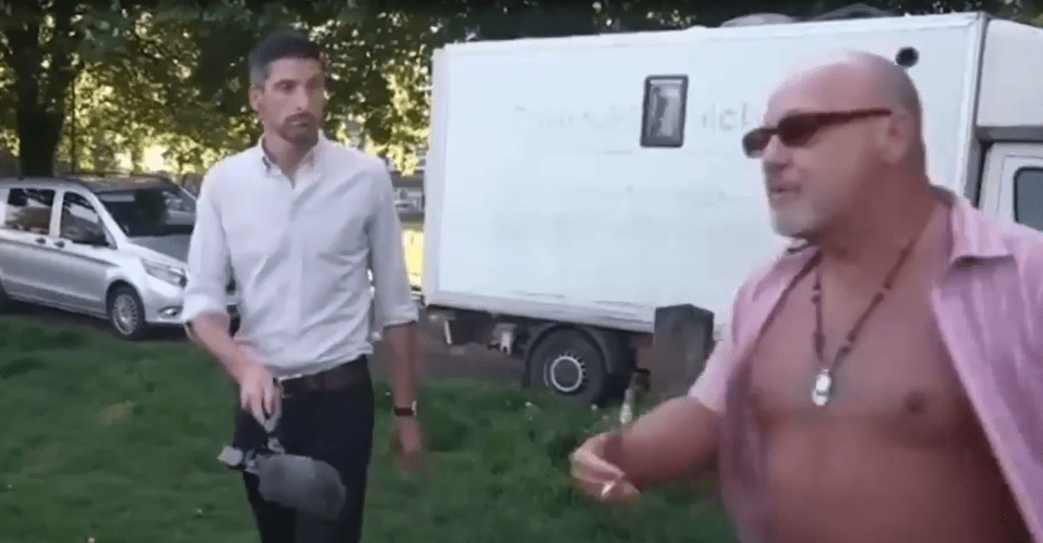 A reporter interviewing a man outdoors.
