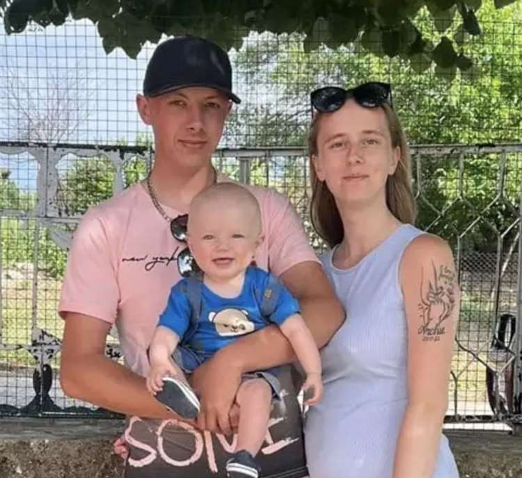 Photo of a family: a man, a woman, and their baby.
