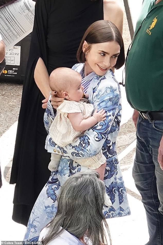 Exclusive pictures show Lily Collins, 36, (pictured) dressed in a floral blue and white trouser suit while between takes for her role as American marketing executive Emily Cooper in Netflix show 'Emily in Paris'