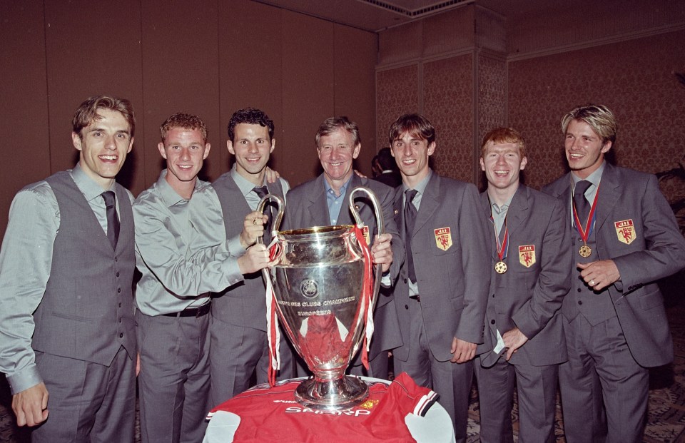 Manchester United players and their coach with the Champions League trophy.