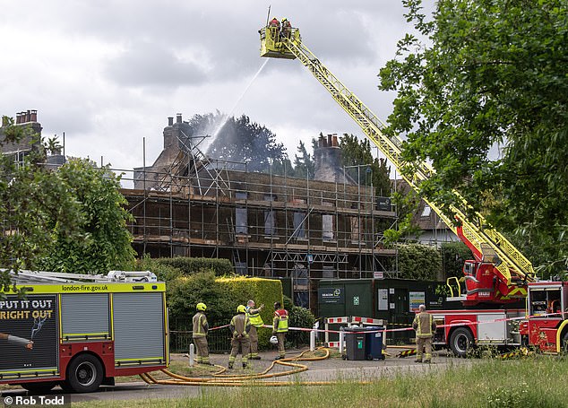 Firefighters continue to dampen down Georgian mansion Hollybush House in Barnet this morning after a horror fire