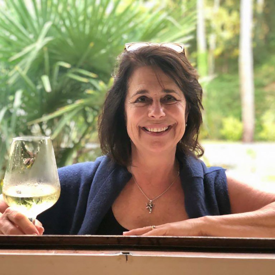 Woman holding a glass of white wine.
