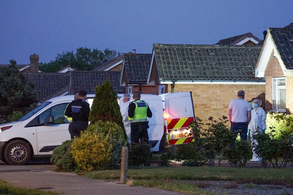 Police officers and forensic investigators at a residential crime scene.