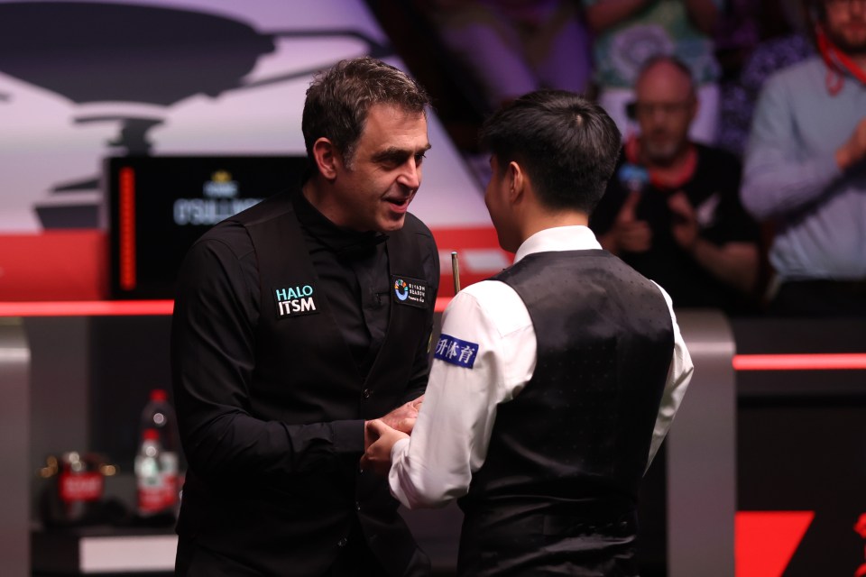 Ronnie O'Sullivan and Zhao Xintong at a snooker match.