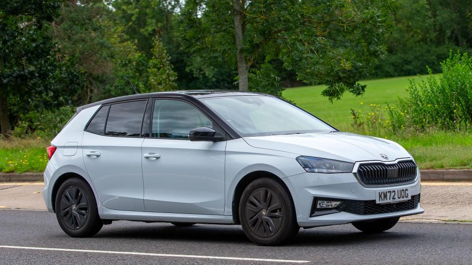 White Skoda Fabia driving on a road.
