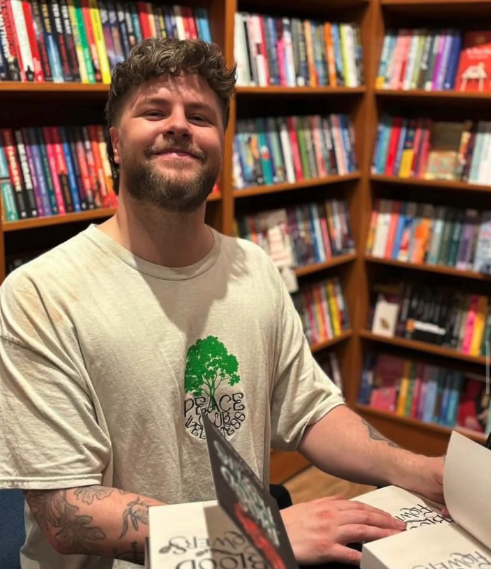 Jay McGuiness signing books in a bookstore.