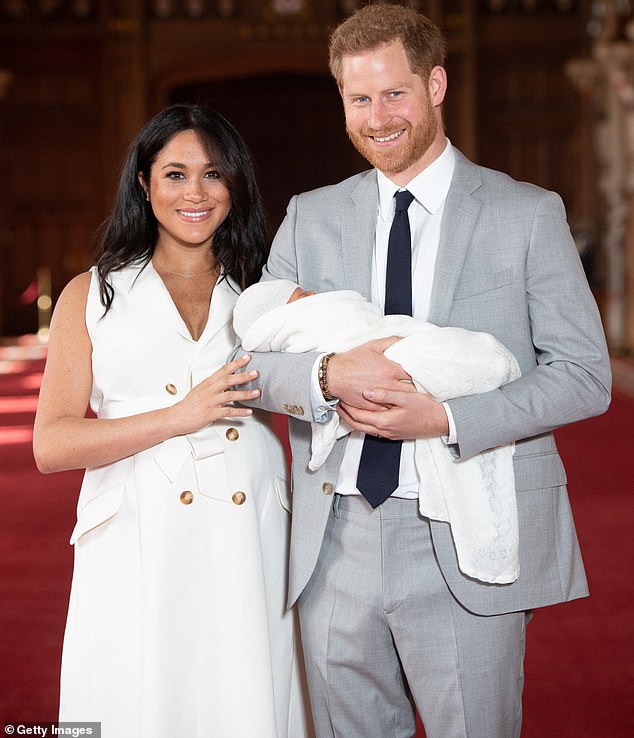Harry and Meghan pose with their newborn son Archie Harrison Mountbatten-Windsor during a photocall in St George's Hall at Windsor Castle on May 8, 2019