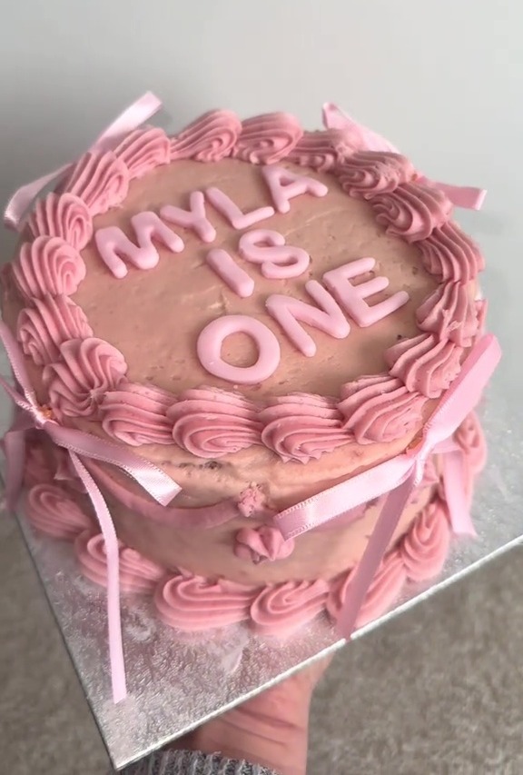 Pink birthday cake that says "Myla is One."