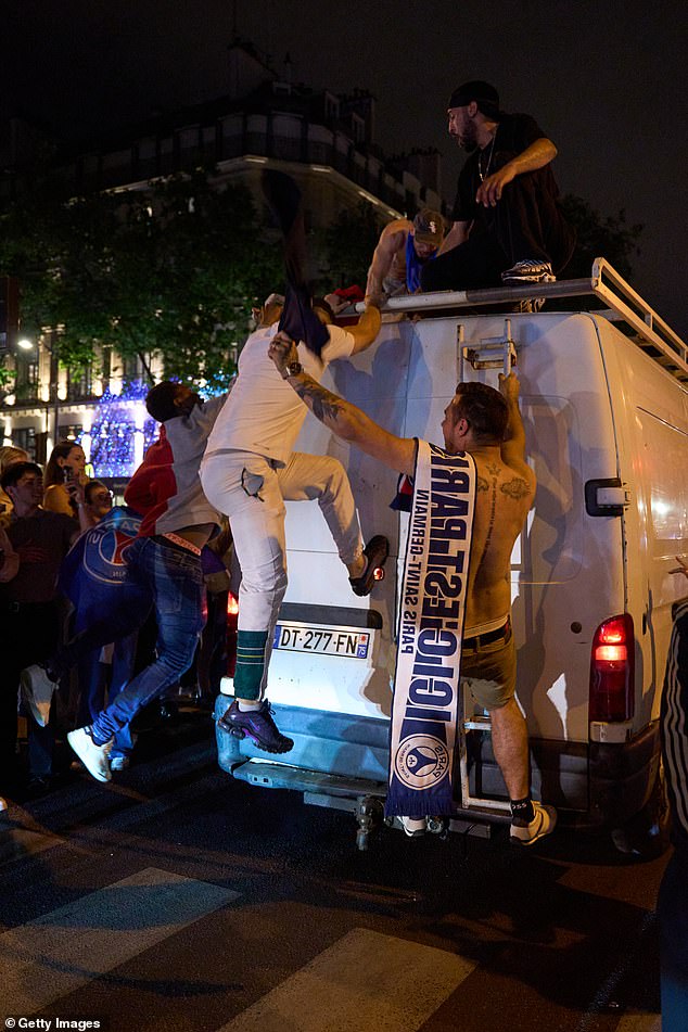 Some fans climbed on top of cars to continue the celebration in tot he night, damaging and vandalising property throughout the city