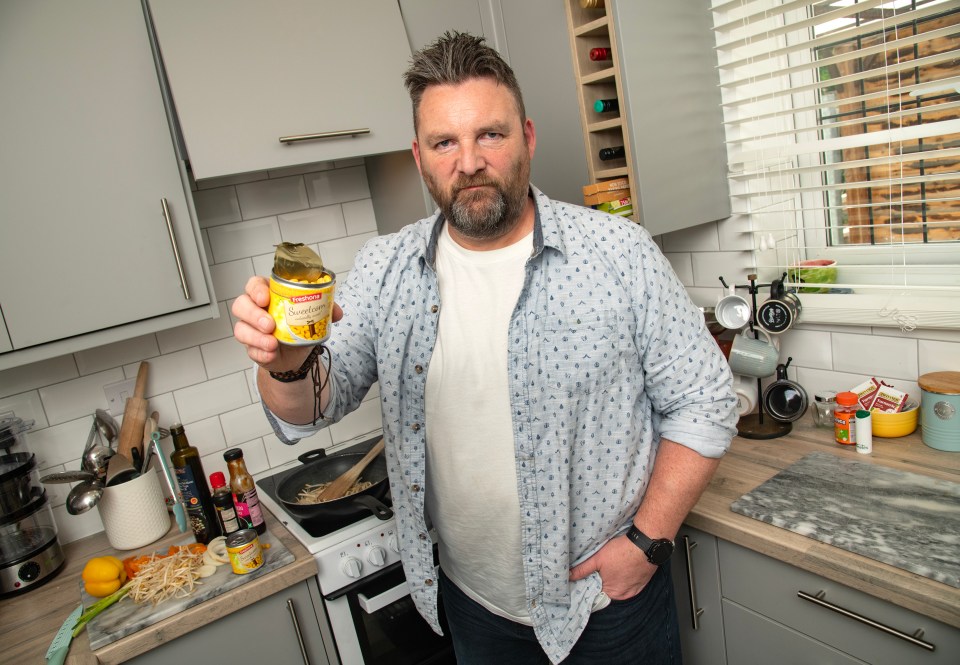 Man holding a can of sweetcorn containing a gecko.