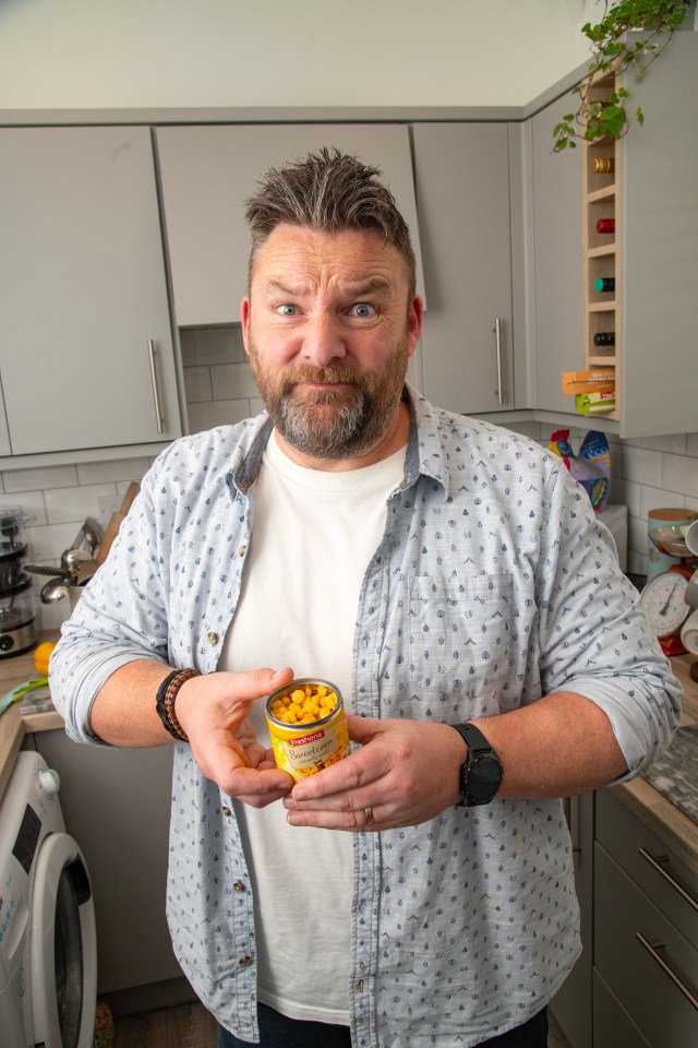 Man holding a can of sweetcorn with a surprised expression.