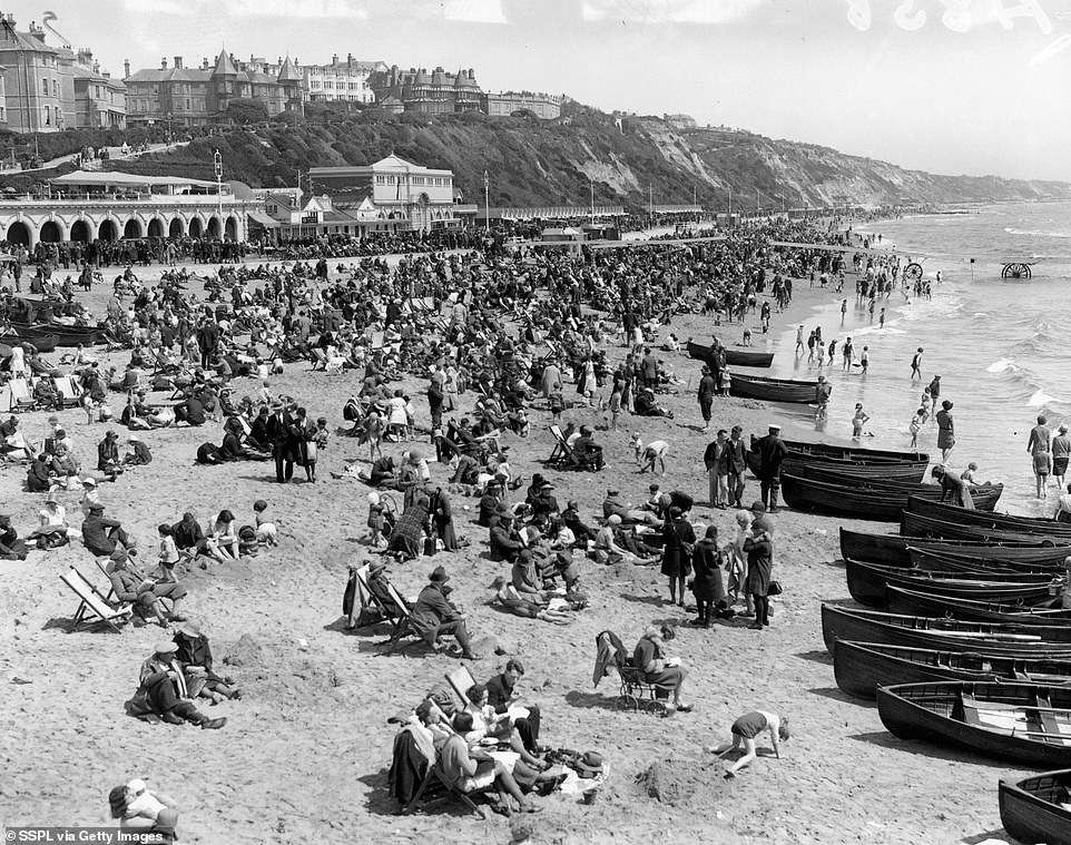 Holidaymakers are photographed on the beach at Bournemouth in 1931. The Bournemouth Belle train launched in 1931 and carried Londoners to Bournemouth on a direct journey