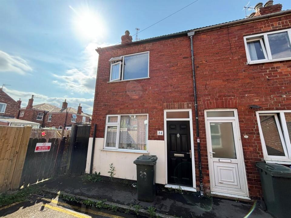 Brick terraced house with black front door.