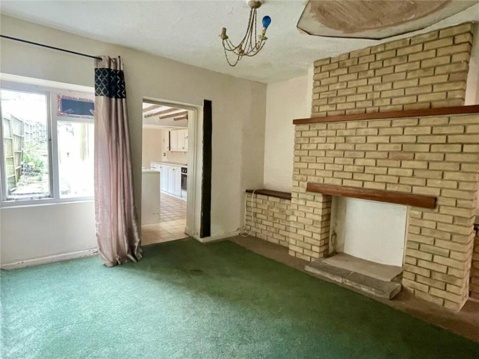 Living room with fireplace and view of kitchen.