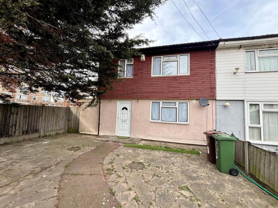 Front of a semi-detached house with a paved yard.