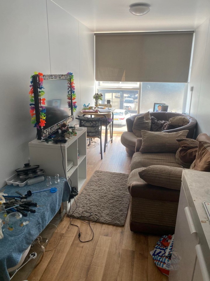Interior view of a small, furnished shipping container home.