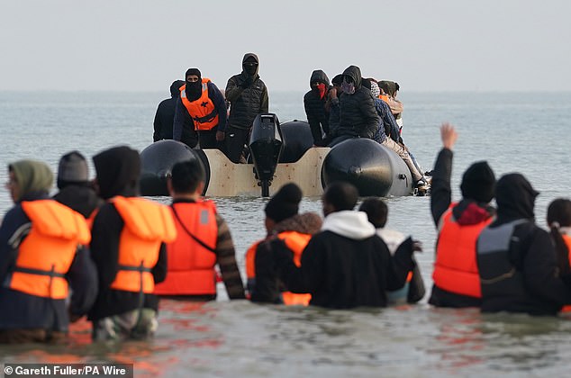 People hoping to reach the UK to claim asylum wade into the Channel to catch a dinghy piloted by several men