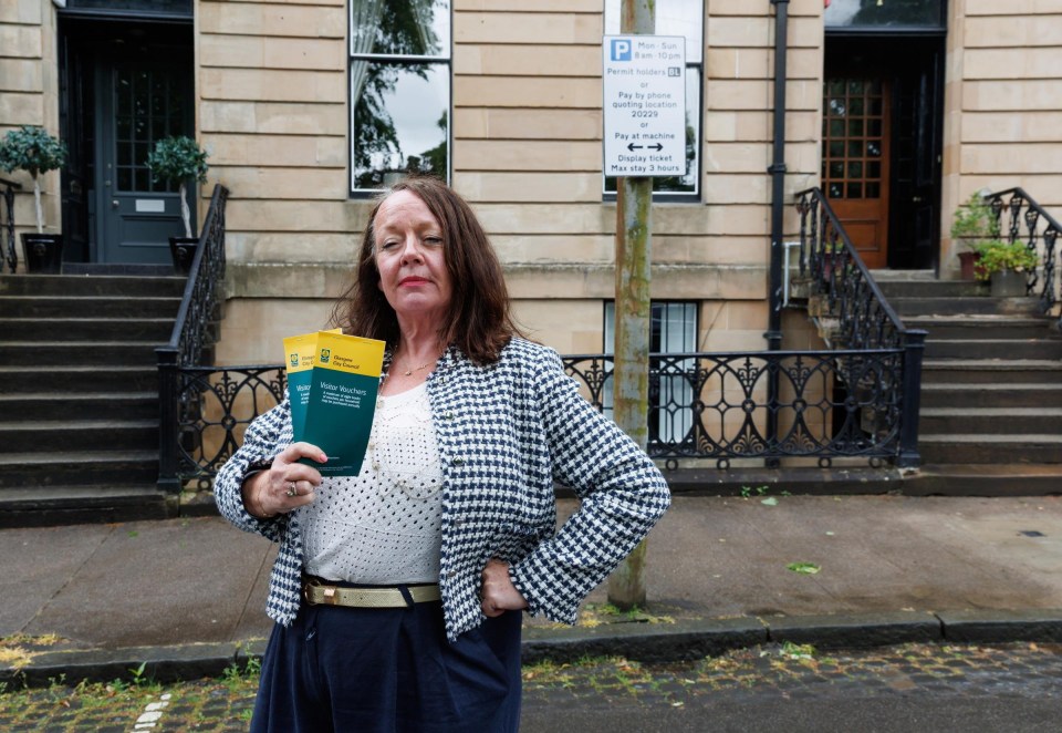 Woman holding parking permits, complaining about parking enforcement.