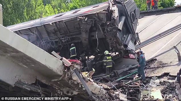 This video grab from a handout footage released by Russia's emergency ministry on June 1, 2025 shows specialists working at the scene after a road bridge collapsed onto a railway line late on May 31, 2025
