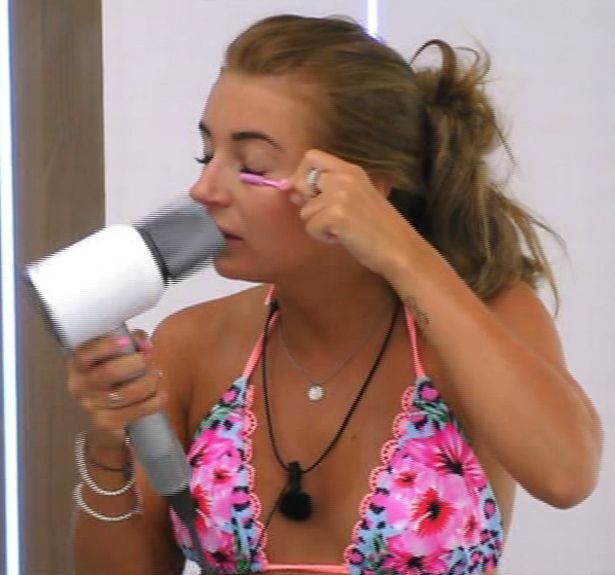Woman curling her eyelashes with a hairdryer.
