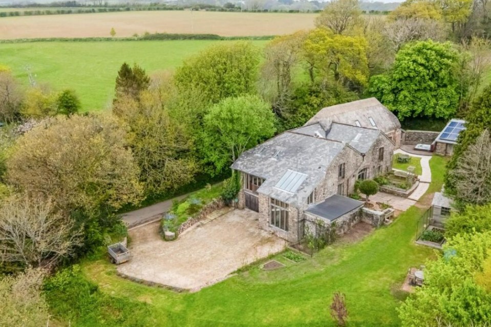 Aerial view of a stone barn conversion in a rural setting.