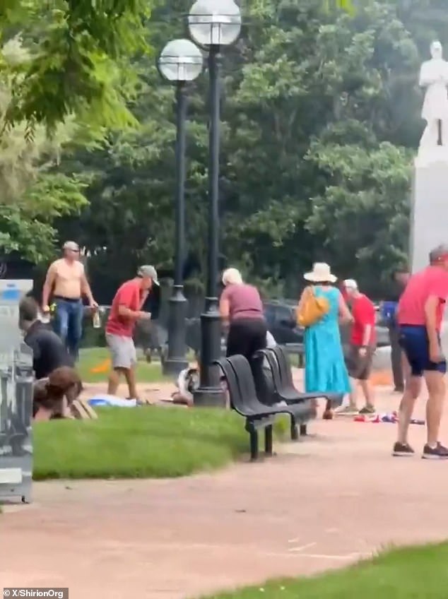 The suspect can be seen in the background, left, carrying a couple of glass bottles. Some are seen on the ground lying motionless while other try to understand the unfolding chaos