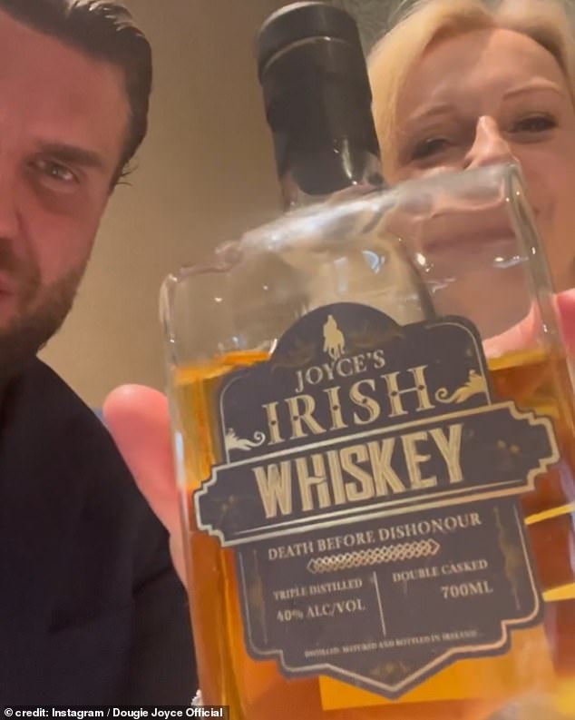 The former Prime Minister looked in great spirits as she waved a bottle of Joyce's booze towards the camera just months after he was freed from jail