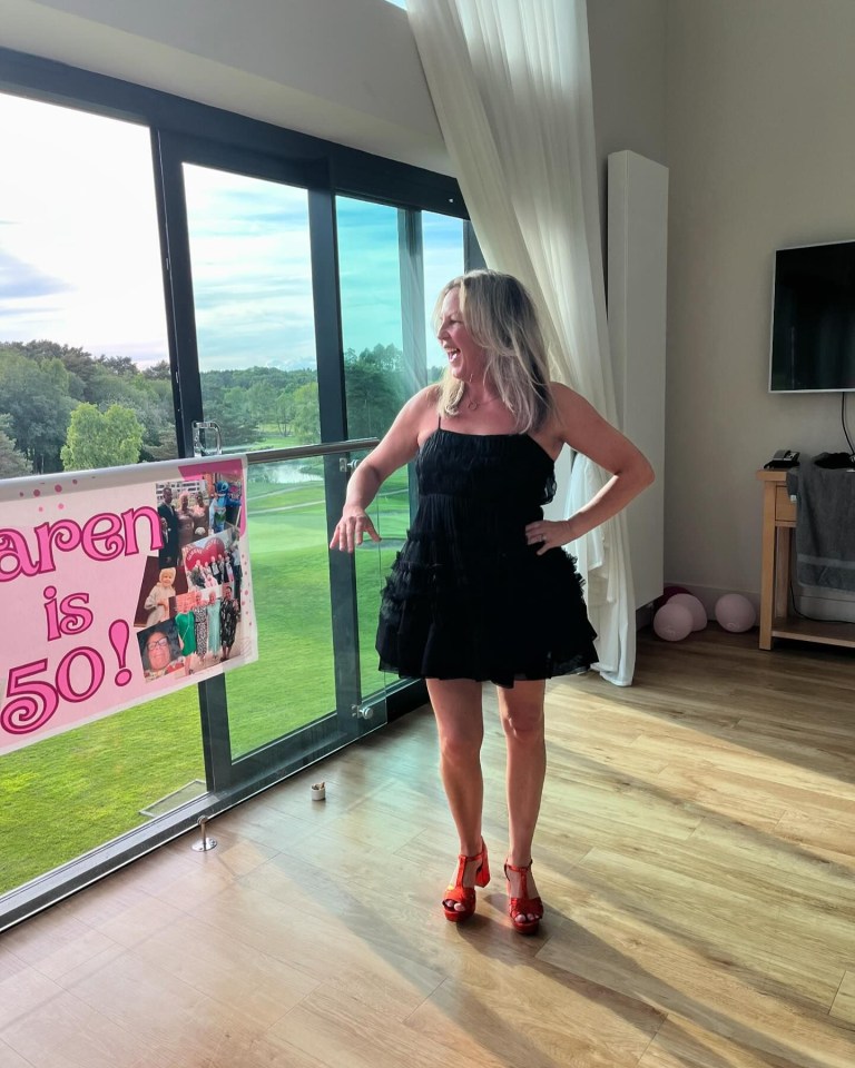 Woman in black dress at a 50th birthday party.
