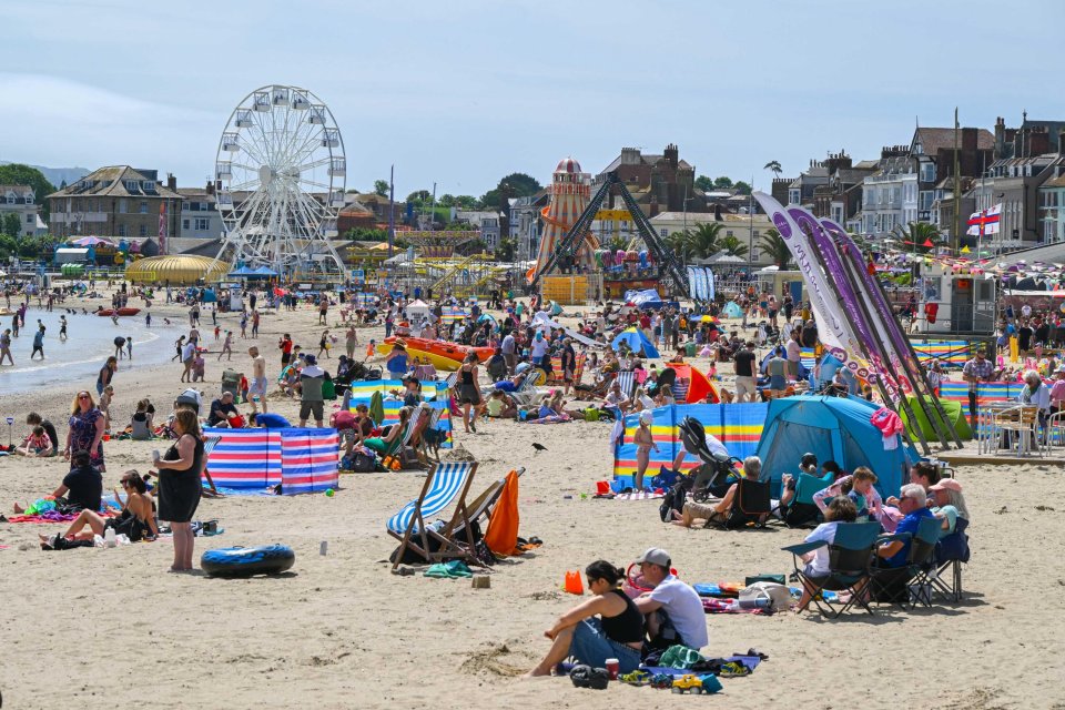 Busy beach with families enjoying the sun and seaside attractions.