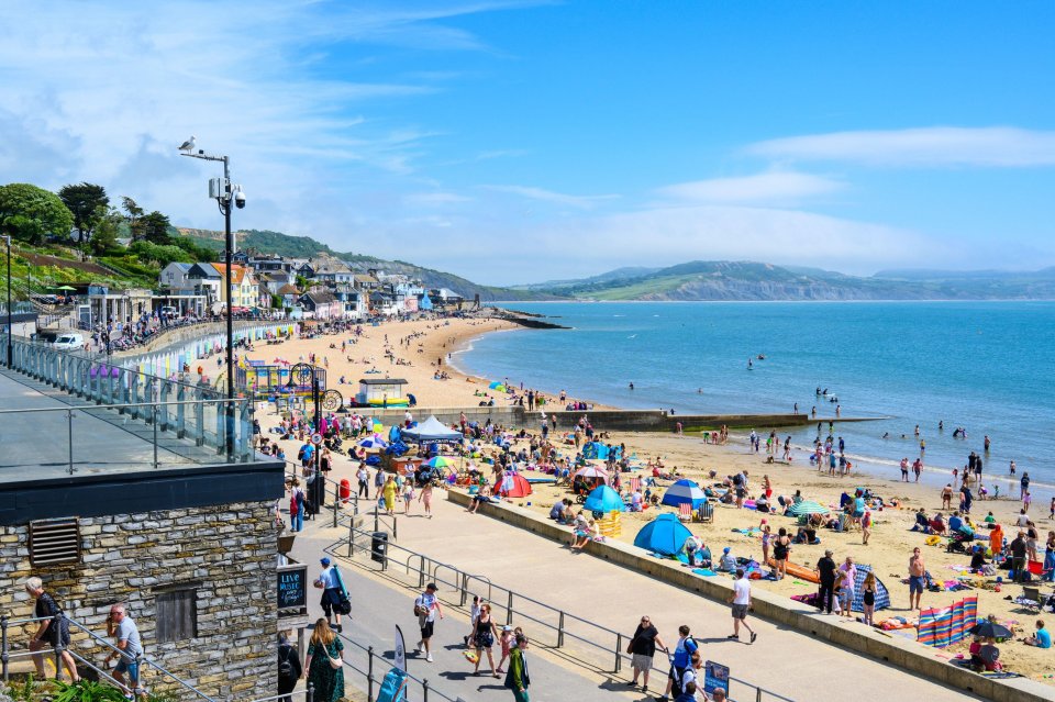 Crowded beach in Lyme Regis, Dorset, UK, on a sunny day.
