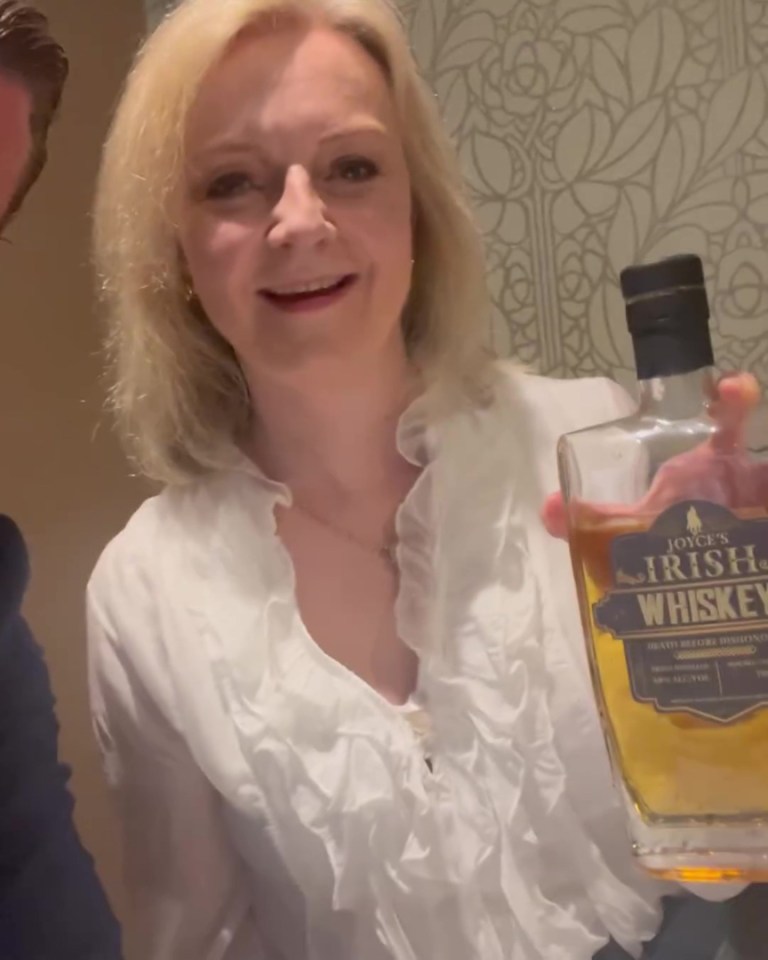 Woman holding a bottle of Joyce's Irish Whiskey.