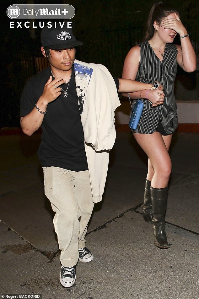 Pax held hands with one of his unnamed female companions at one point, who tried to shield her face from the paparazzi