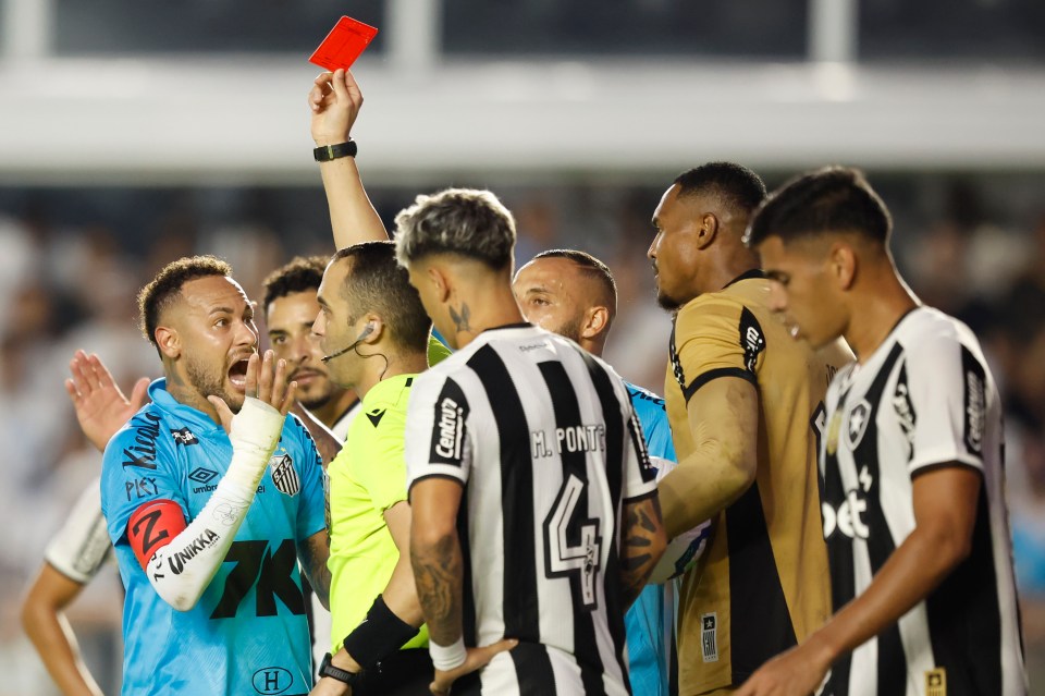 Neymar of Santos receives a red card during a soccer match.