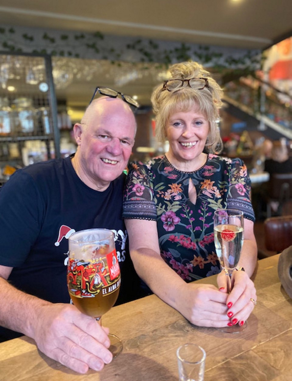 A man and woman sitting at a bar, enjoying drinks.