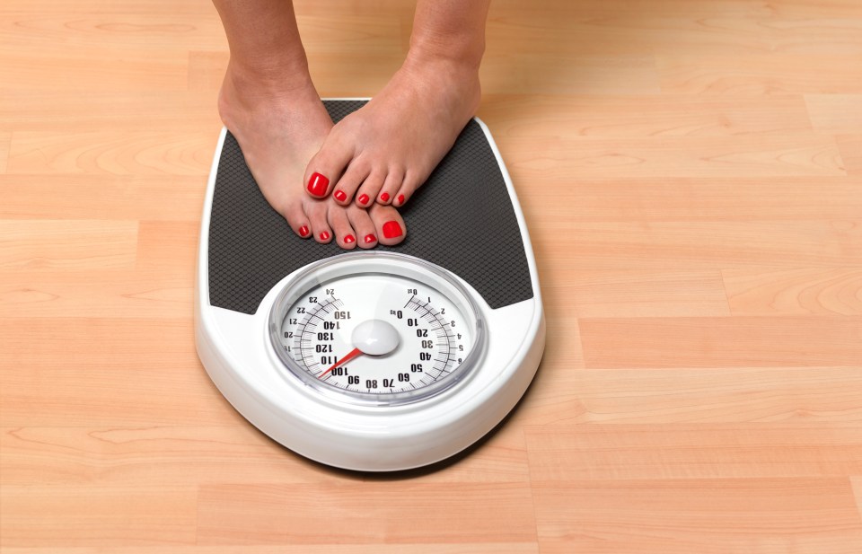Woman's feet on a bathroom scale.
