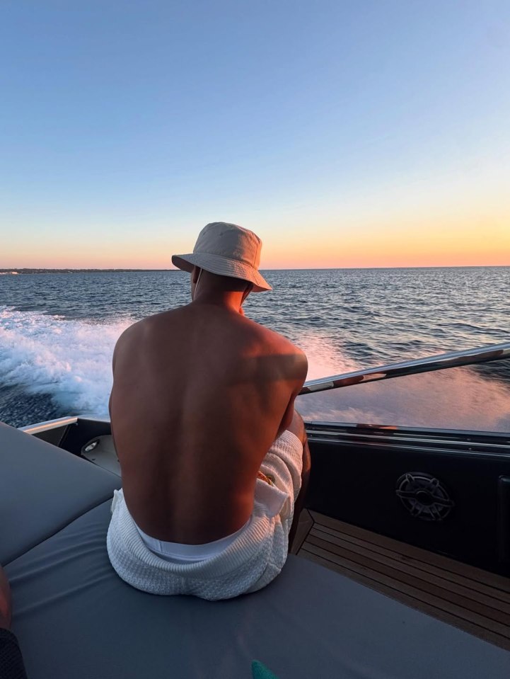 Man sitting on a boat at sunset.