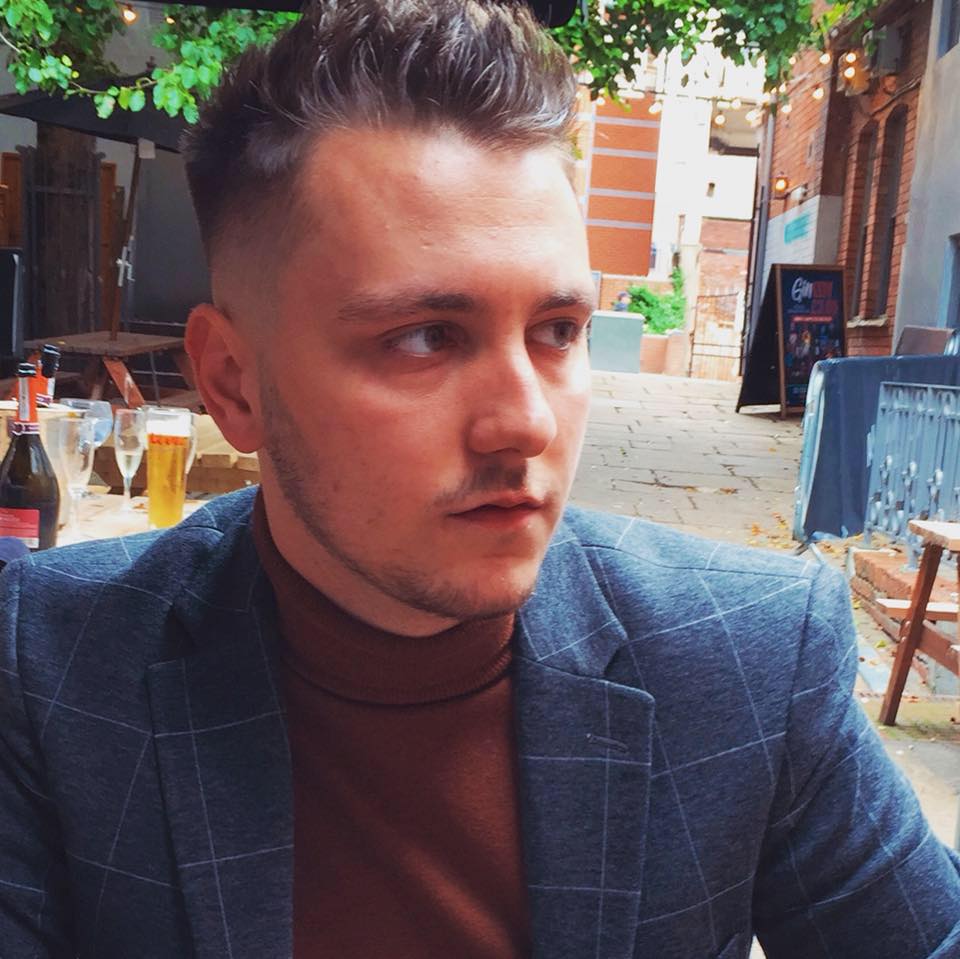Photo of a man in a suit looking off to the side.