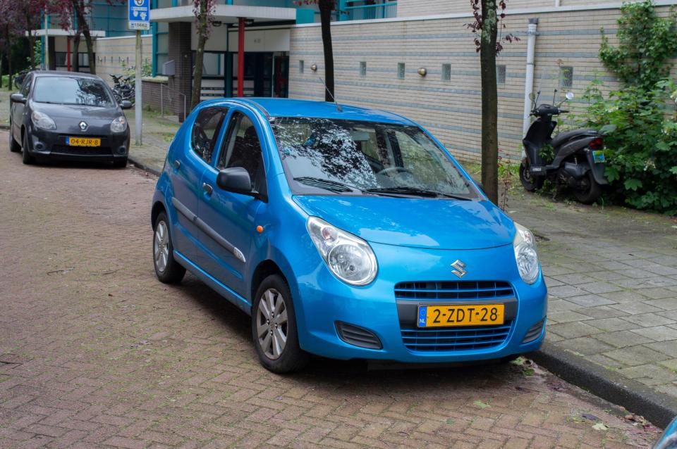 Blue Suzuki Alto parked on a residential street.