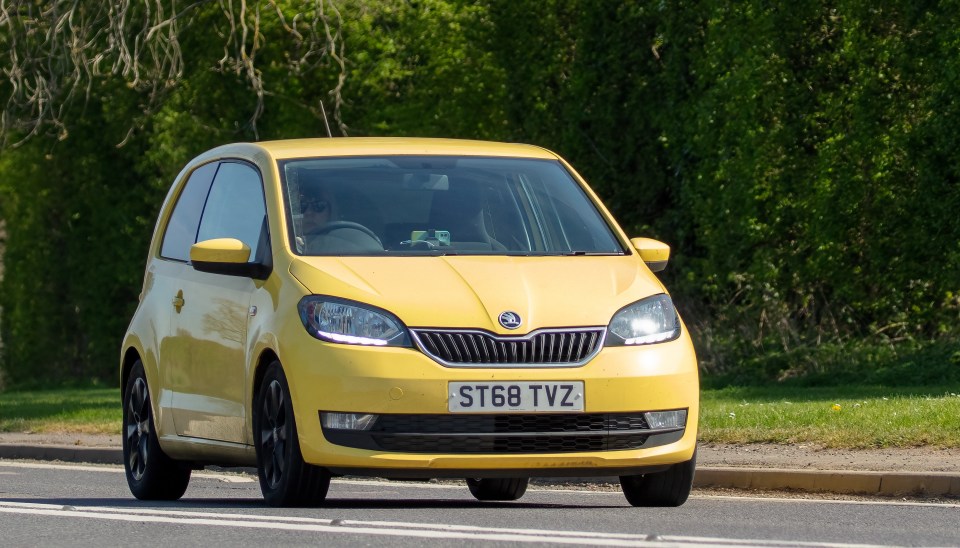 Yellow Skoda Citigo driving on a road.