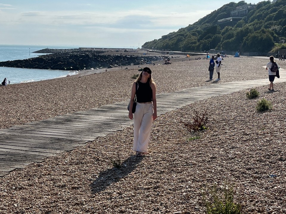 Woman walking on a beach boardwalk.