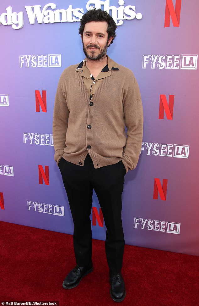 For the special event, Brody wore a cozy, brown knit cardigan layered over a printed button-down. He sported black trousers and matching, leather dress shoes to complete his sharp outfit