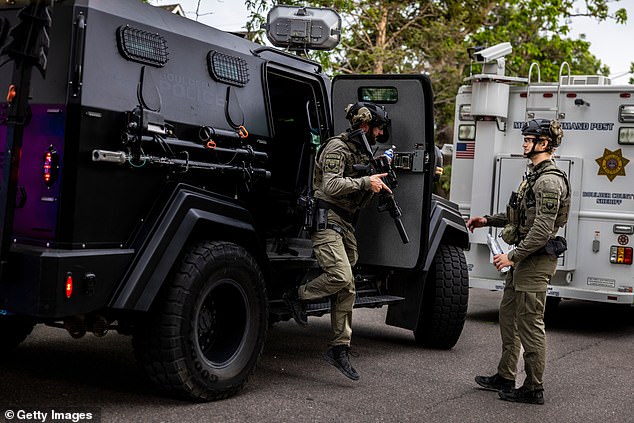 Members of a law enforcement tactical team get in place after the horrifying incident in downtown Boulder, Colorado, on Sunday