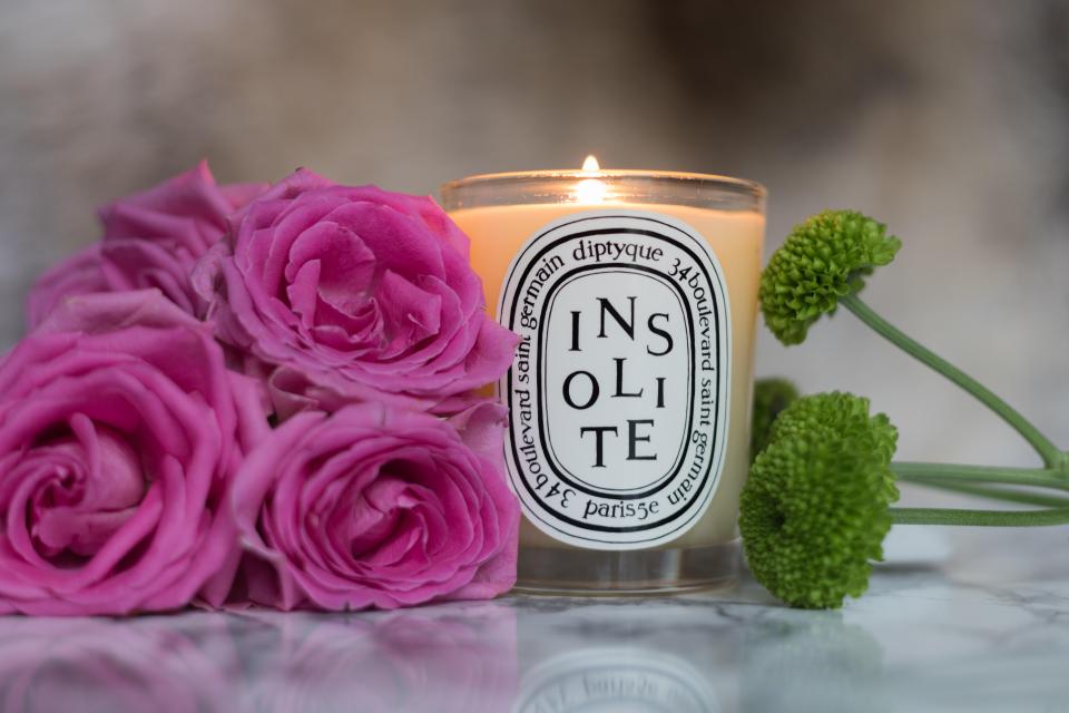 Diptyque Insolite candle with pink roses and green flowers.