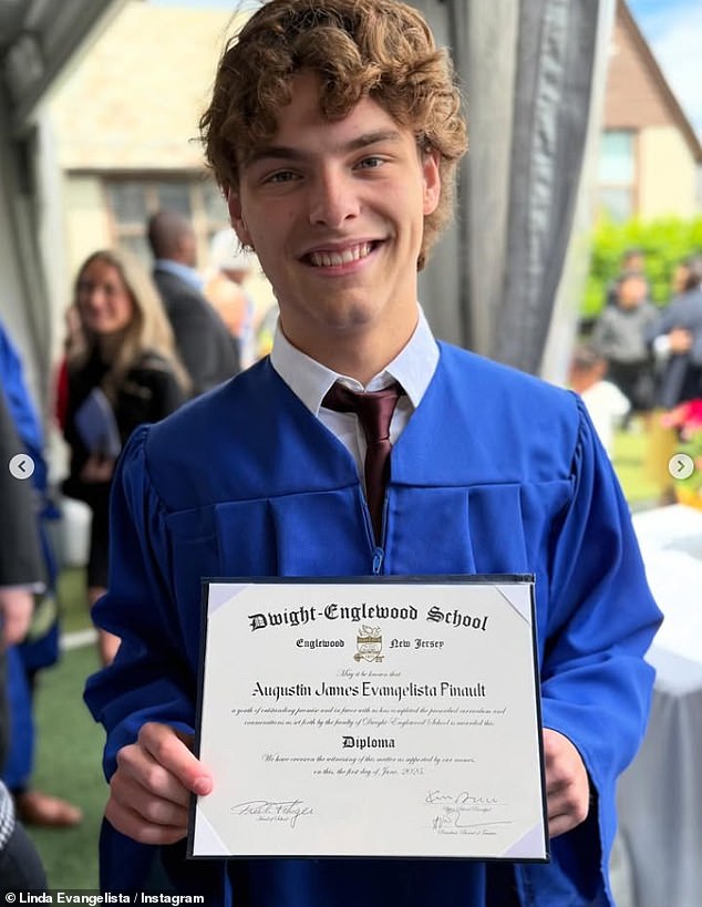 Augustin proudly posed with his high school diploma while clad in his graduation gown