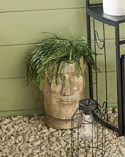 Easter Island head planter with grass.
